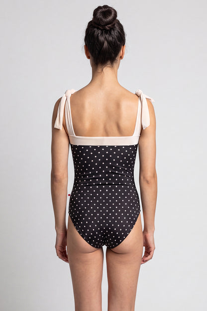 AI-generated model. Mimi leotard, black T-Lunares polka-dot body with a blush square neckline and knotted tie shoulder straps.