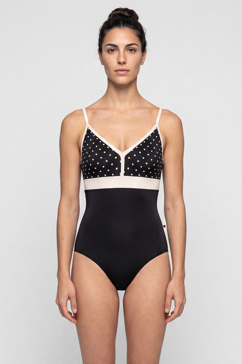 AI-generated model. Zoe leotard, black T-Lunares polka-dot V-neck bust with blush straps and waistband, black body.