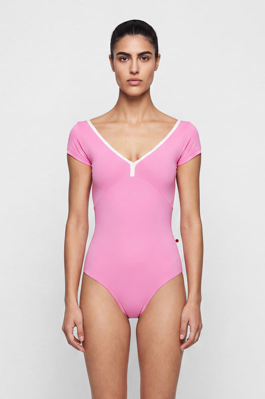 AI-generated model. Alicia leotard, bright pink with cap sleeves and a V-neck with white centre trim.
