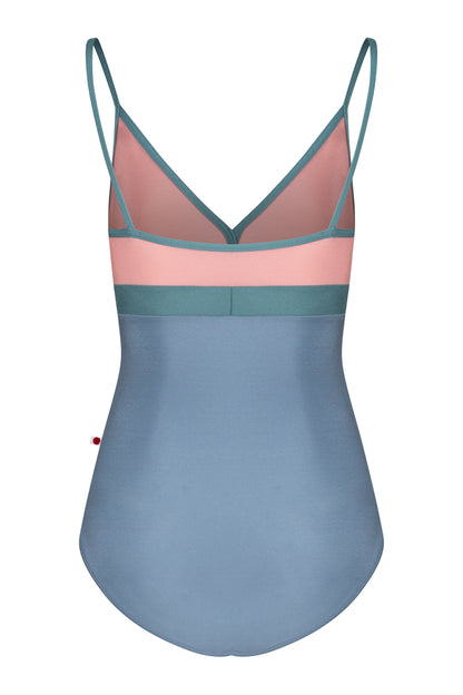 AI-generated model. Zoe leotard, dusty-rose bust and blue-grey body with a teal waistband and thin teal straps, V-neck.