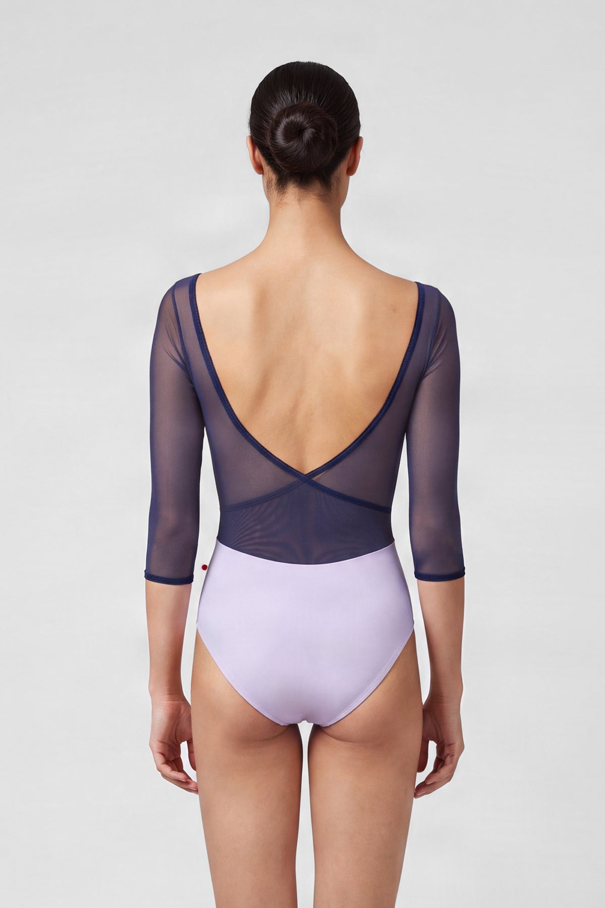 AI-generated model. Masha leotard, lilac with sheer navy mesh three-quarter sleeves and a navy-trimmed V-neck.